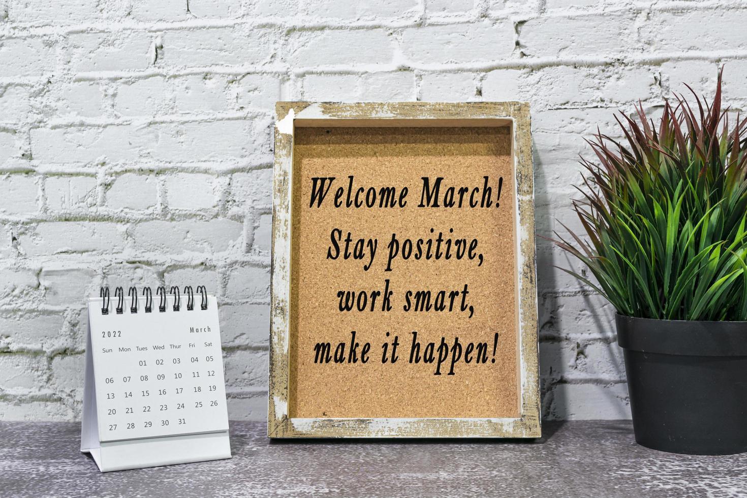 Inspirational and motivational quote on wooden frame and March 2022 calendar. photo