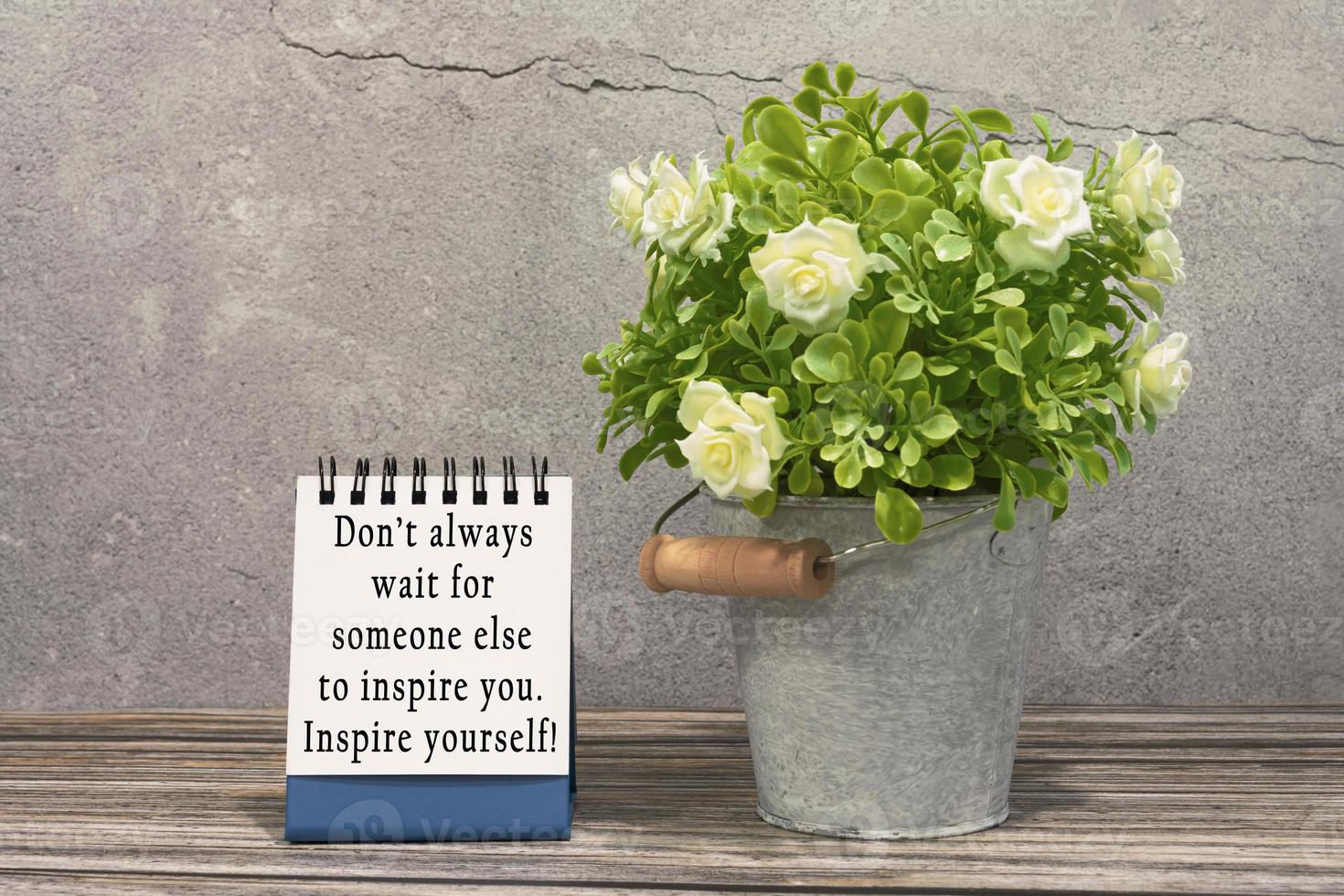 Motivational and inspirational quote on stand note with potted plant on the desk photo