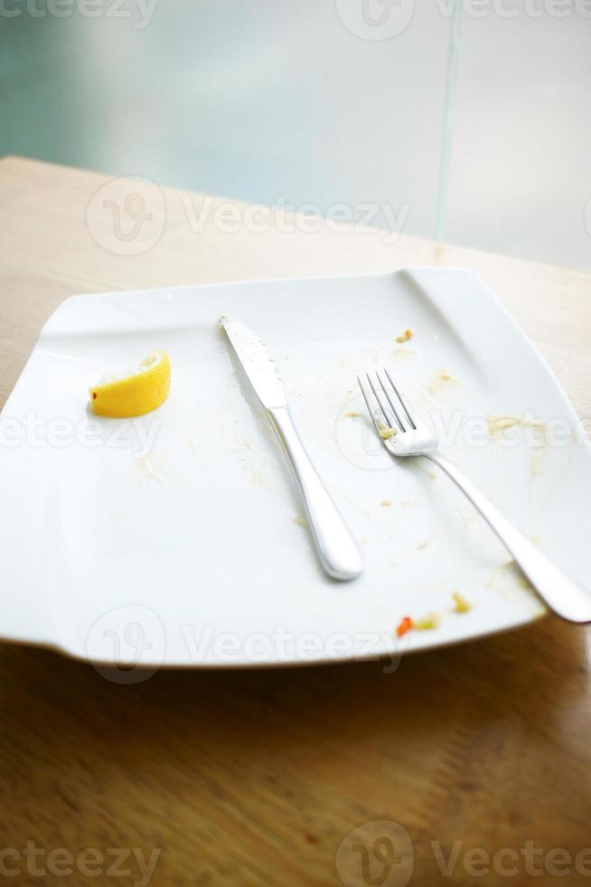 Empty plate after eating on table photo