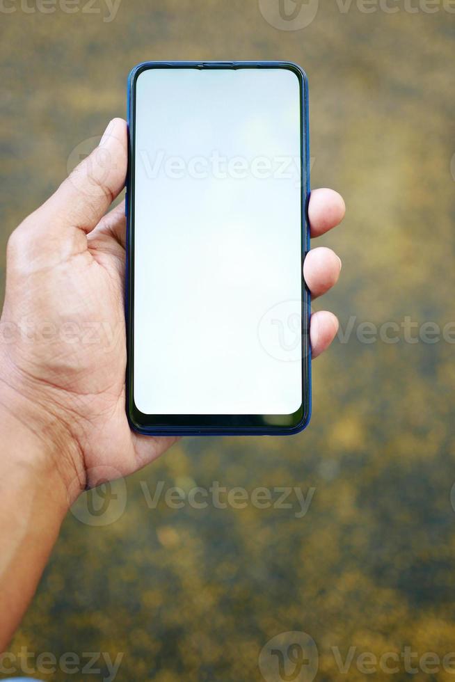 Close up of young man hand using smart phone with green screen photo