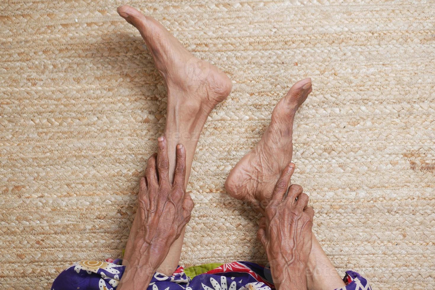 senior women feet and hand massage on injury spot. photo