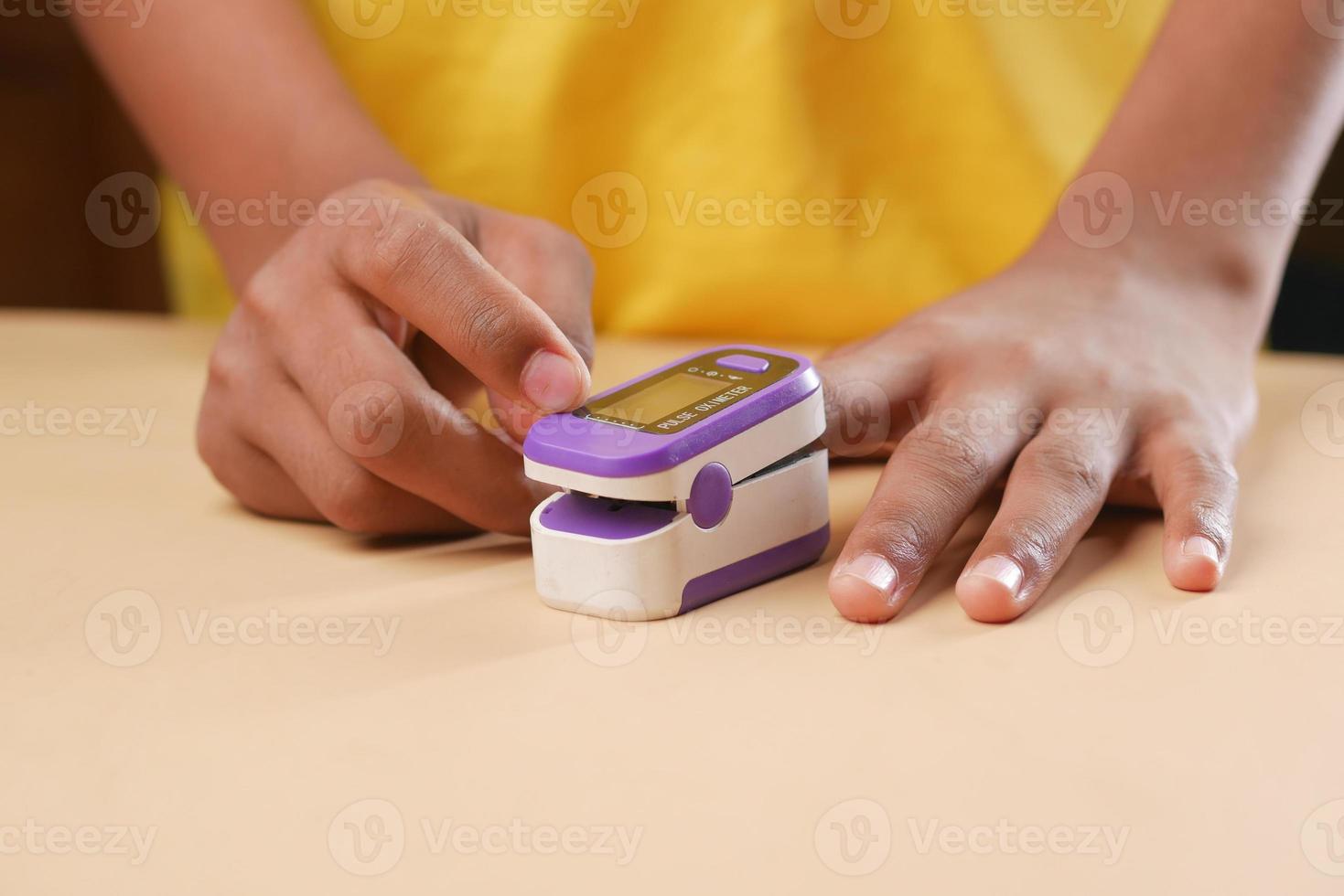 close up of man hand using pulse oximeter photo