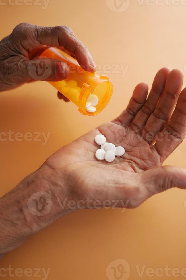 mujeres mayores tomando pastillas a mano foto