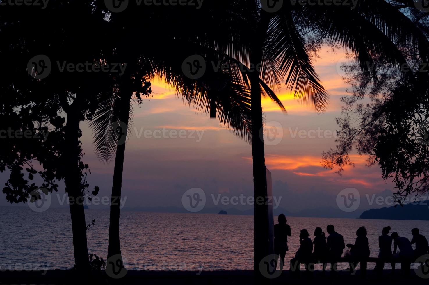 viajero de silueta en el mar y puesta de sol foto