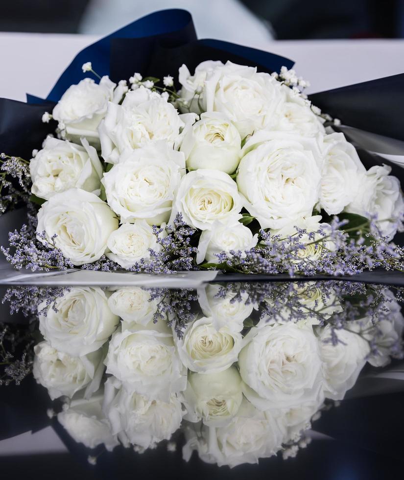 Beautiful big and a luxury bouquet of white roses arranged in a bunch with reflection on the floor photo