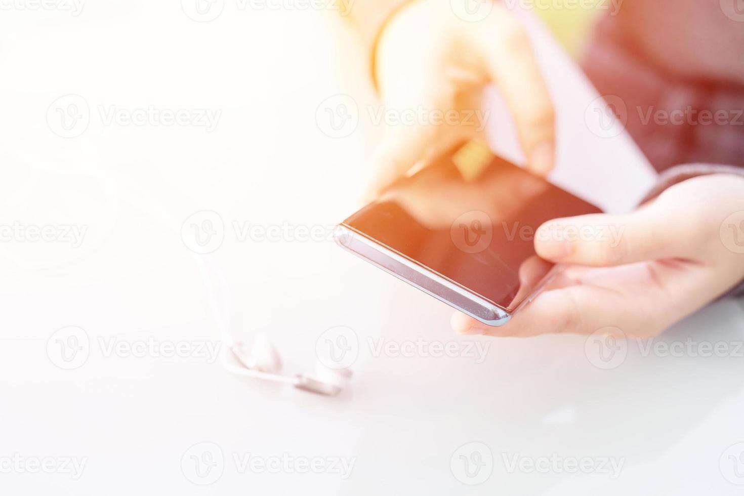 Woman sitting and using smartphone for online shopping with credit card  on deck in home office photo