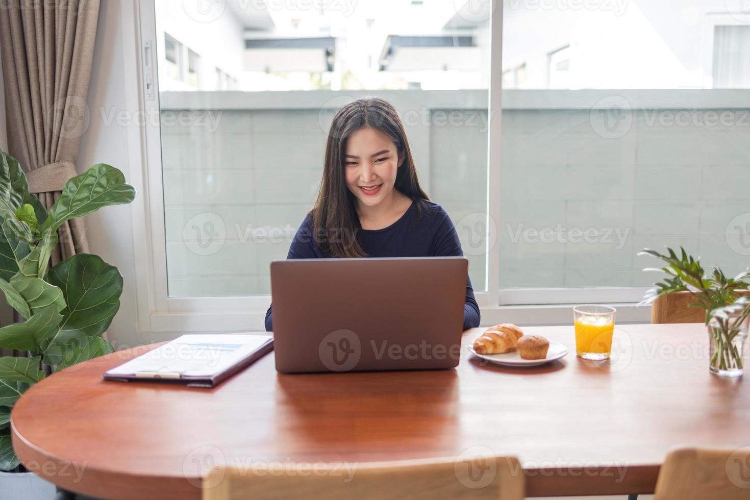 Work from home concept a female freelancer looking happy while working online in her own space during Covid 19 pandemic photo