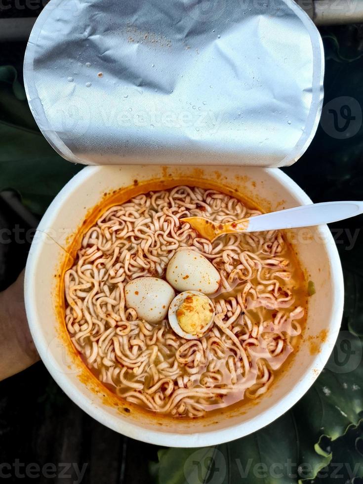 Spicy cup instant noodles with additional toppings of boiled quail eggs, very delicious and savory. photo