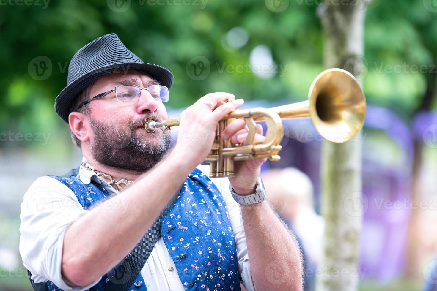 A trumpet player who plays in the street through the streets of the city photo