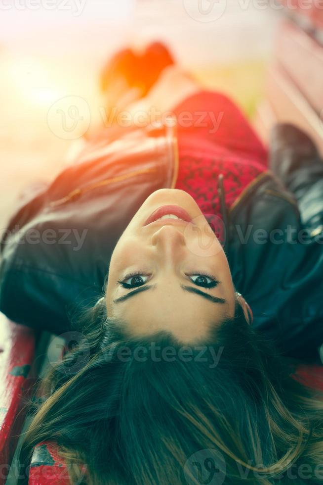Young girl lying on a bench photo