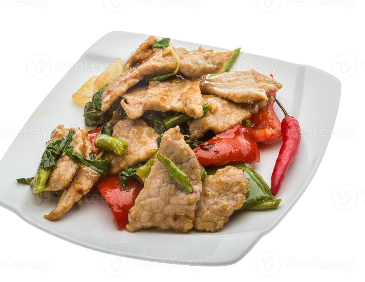 Pork with vegetables on the plate and white background photo