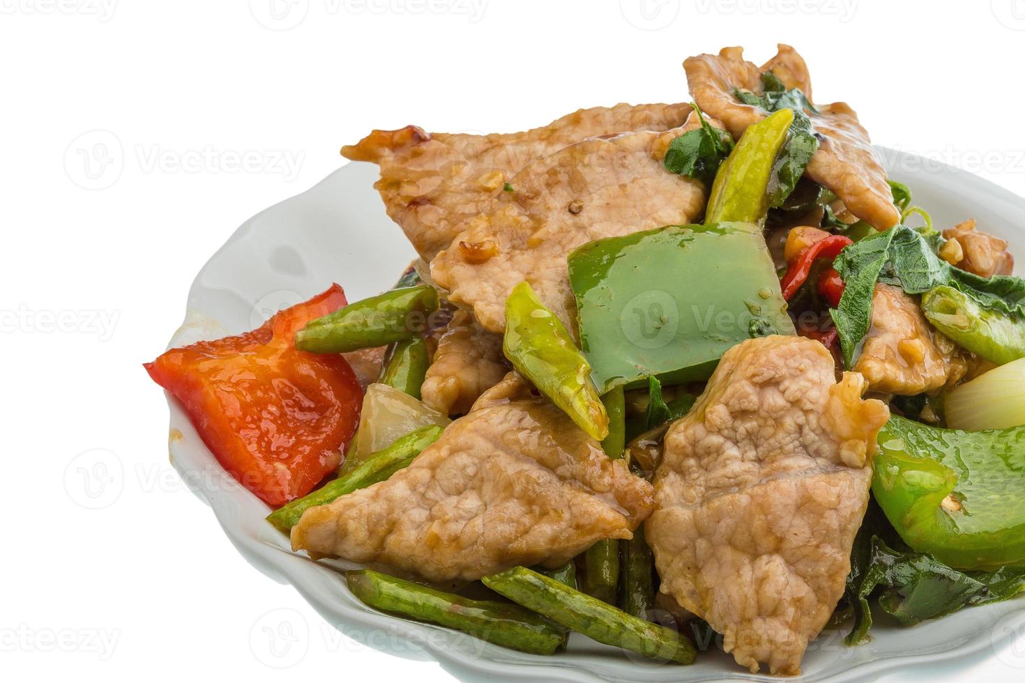 Pork with vegetables on the plate and white background photo