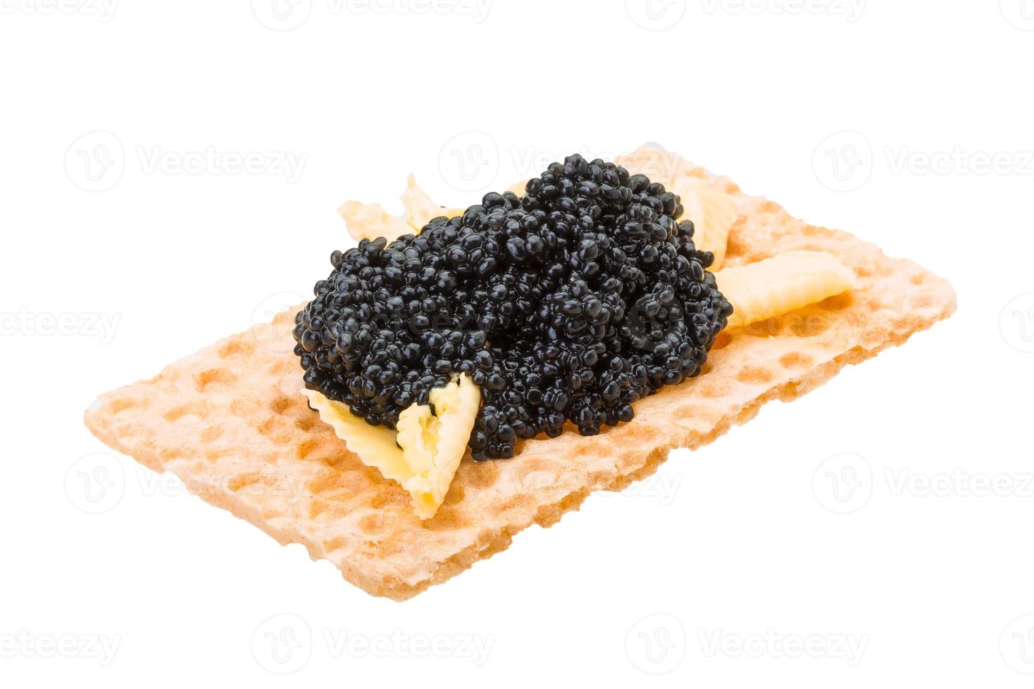 Toast with black caviar on white background photo