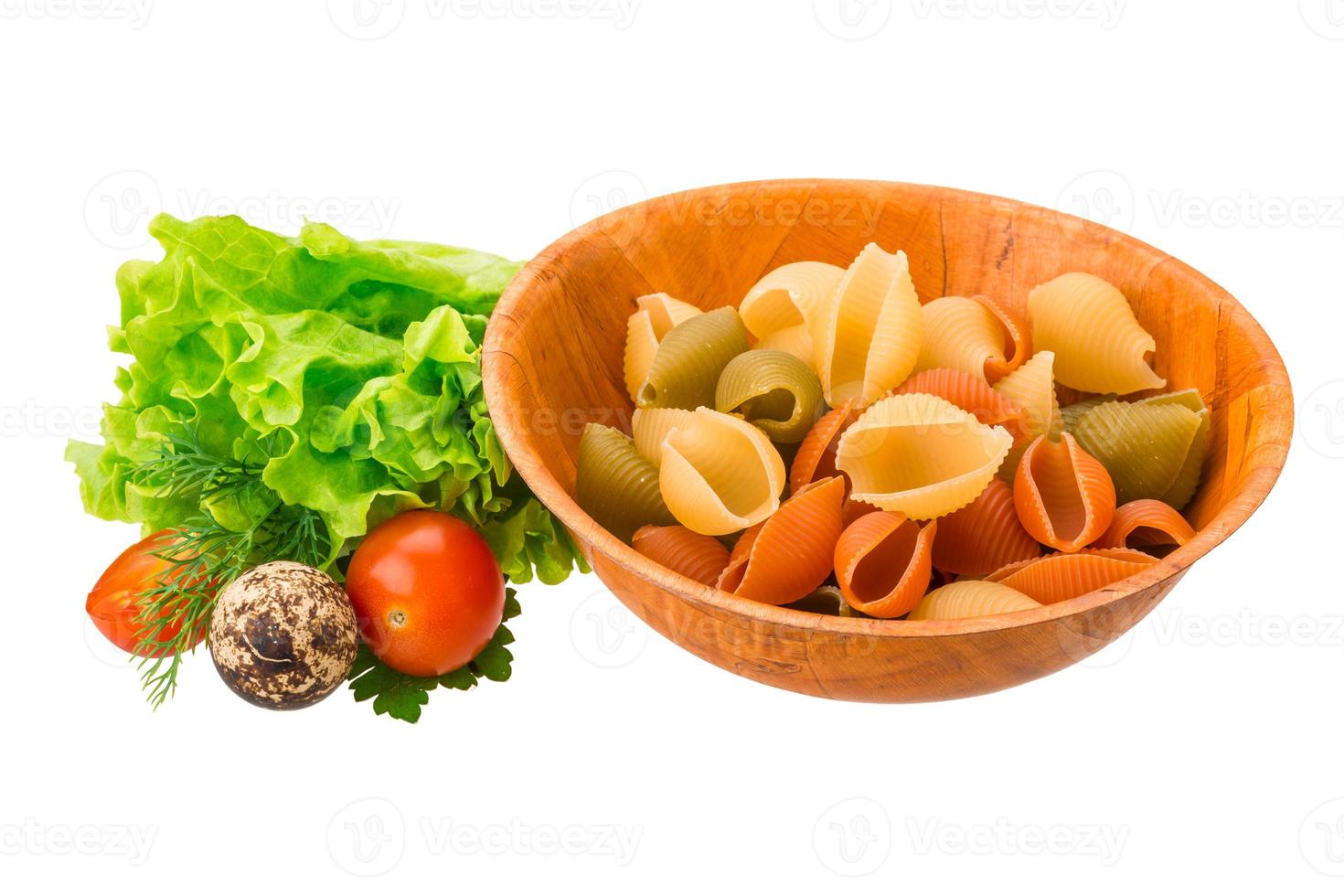 Raw pasta in a bowl on white background photo