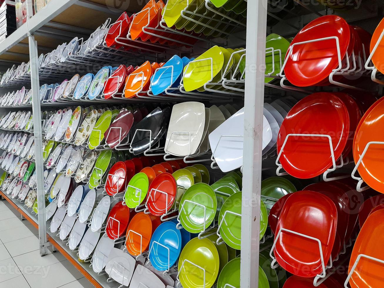 Rows of beautiful colorful plates lined up neatly on shopping mall shelves, can be used to serve dishes in culinary establishments such as restaurants. photo
