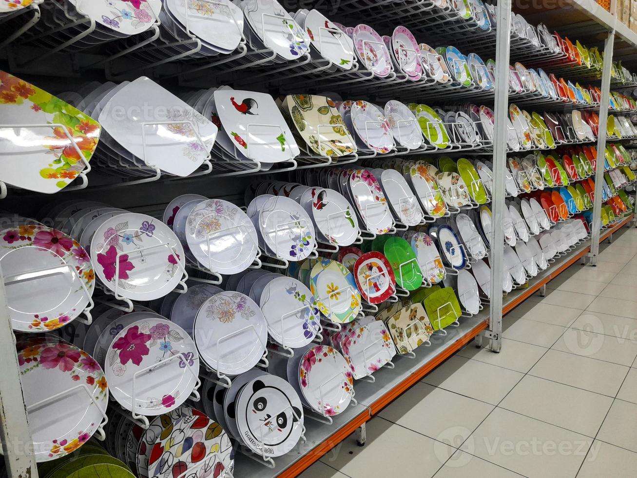 Rows of beautiful colorful plates lined up neatly on shopping mall shelves, can be used to serve dishes in culinary establishments such as restaurants. photo