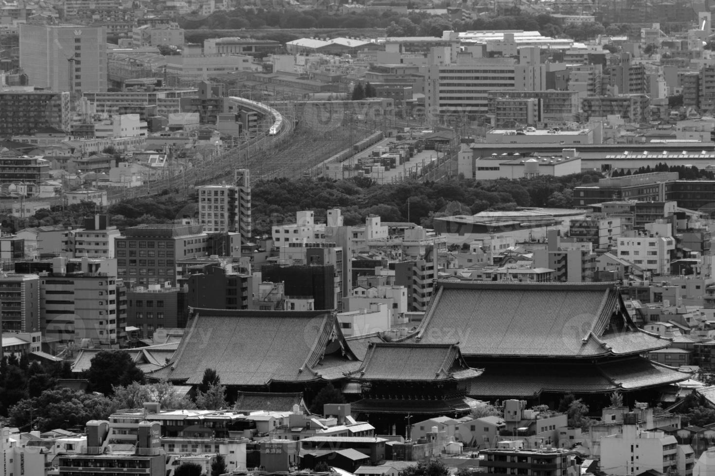 Kyoto temple and bullet train from mountaintop in black and white photo