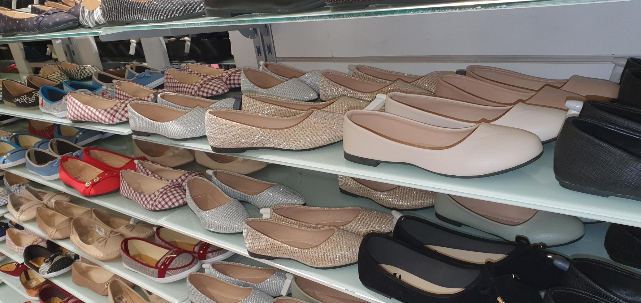 zapatos de moda para mujeres en el estante de exhibición de la tienda de ropa al por menor. foto