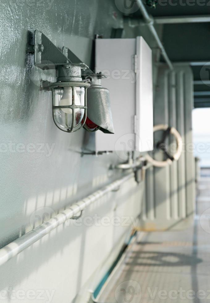 Deck lamp on ship in protective cage photo