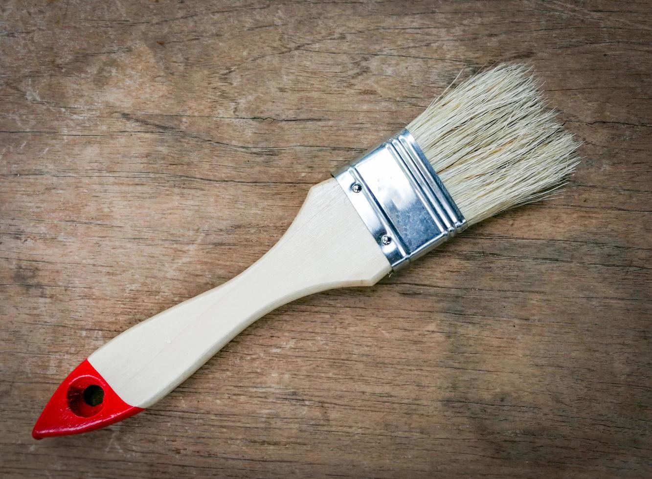 paintbrush for applying paint on old wooden background top view photo