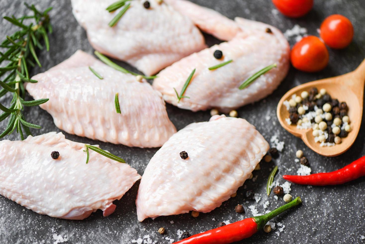 Raw chicken wings, herbs and spices with pepper chili tomato garlic for cooking thai asian food rosemary chicken photo