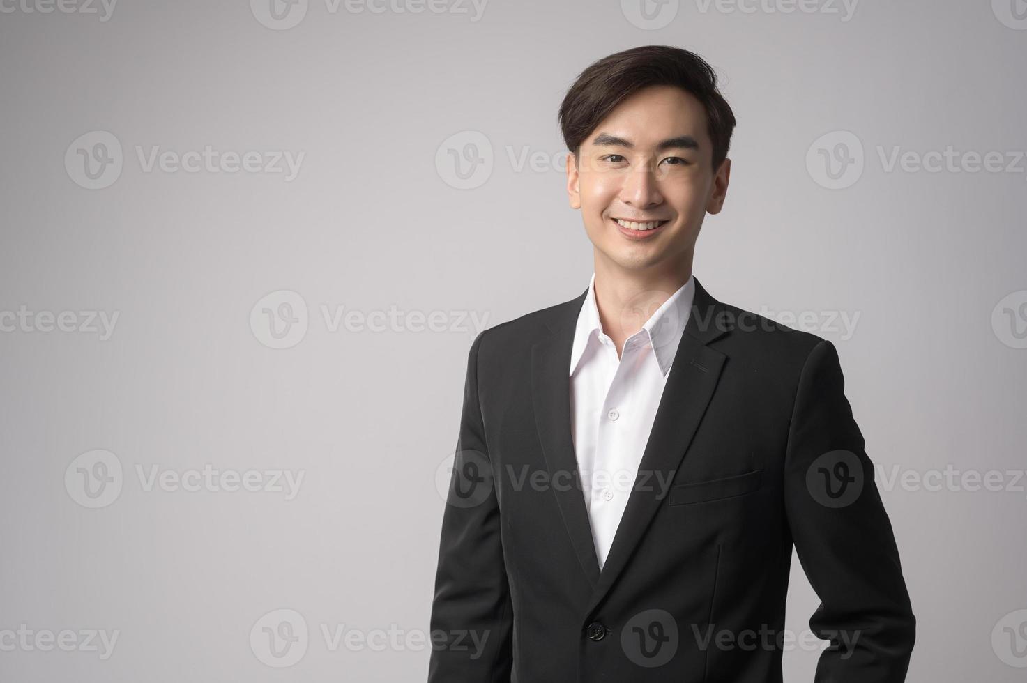 joven empresario vistiendo traje sobre estudio de fondo blanco foto