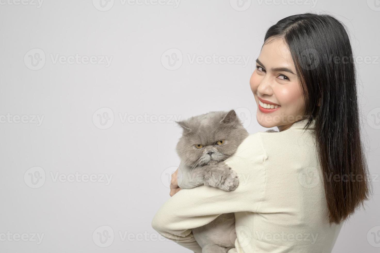 A young woman is holding lovely cat , playing with cat in studio on white background photo