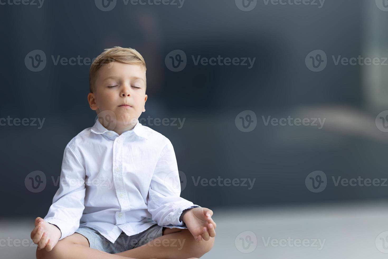 Zen-like boy meditating with eyes closed. photo