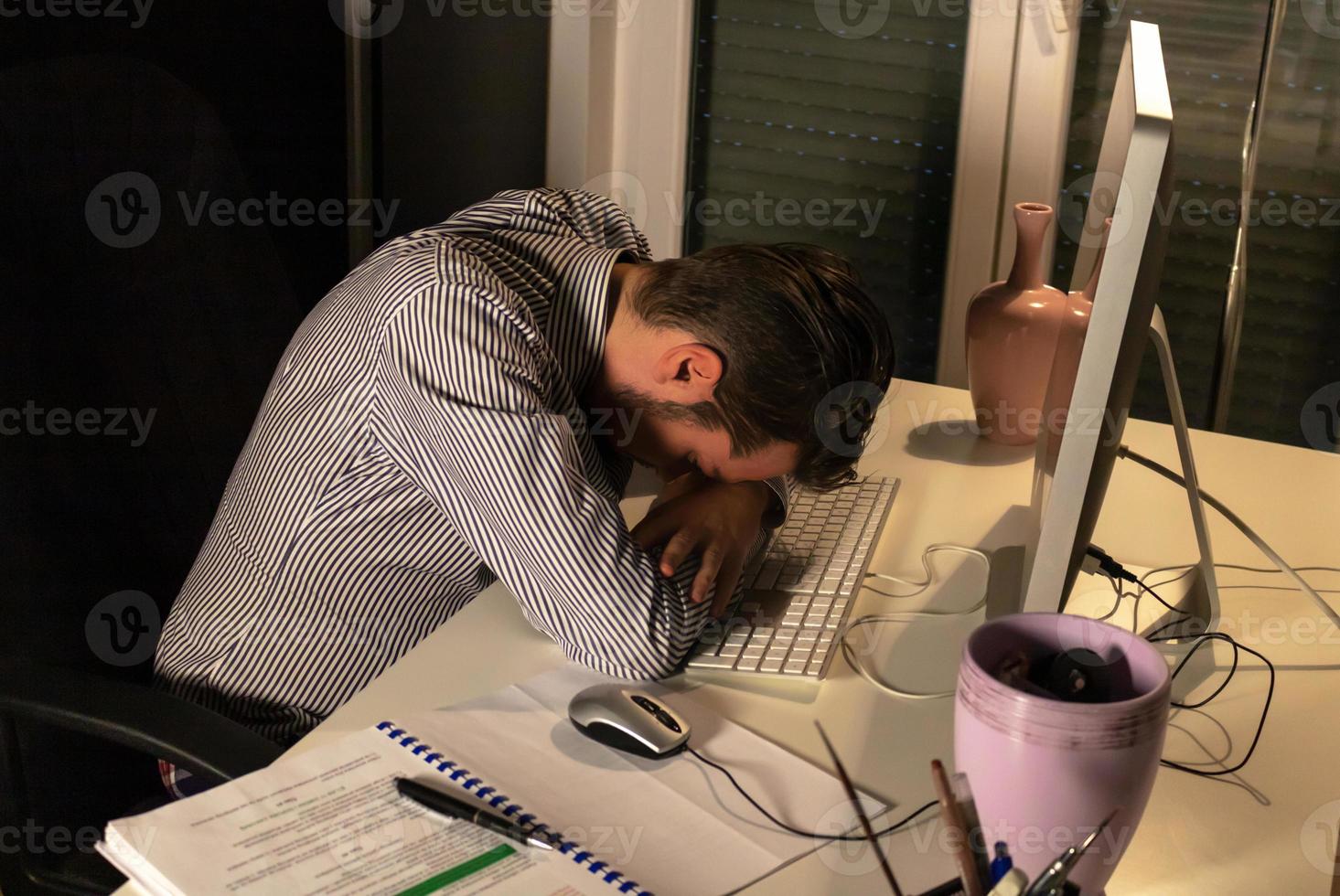 Above view of exhausted businessman at night in the office. photo