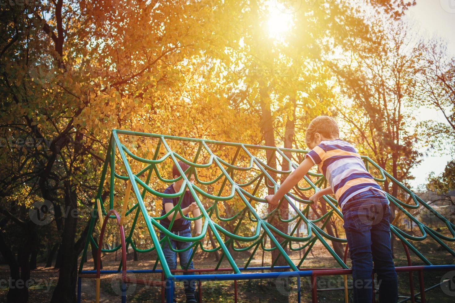 Two boys playing on the playground at the park. photo