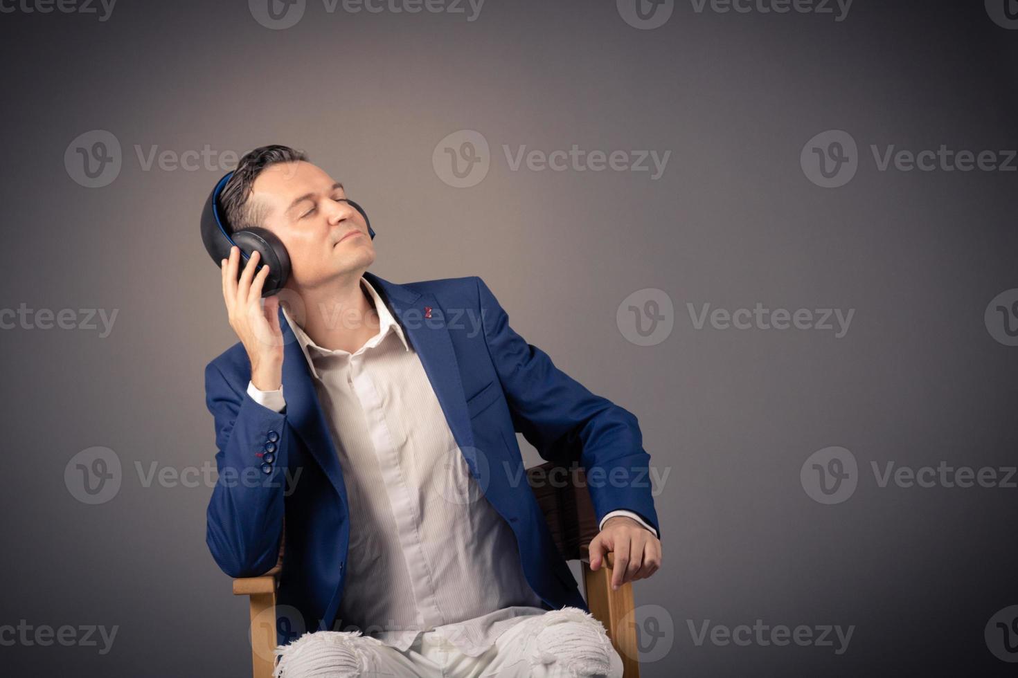 Relaxed businessman listening music on headphones. photo