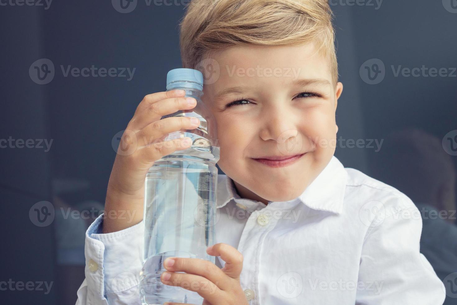 Happy child with water bottle. photo
