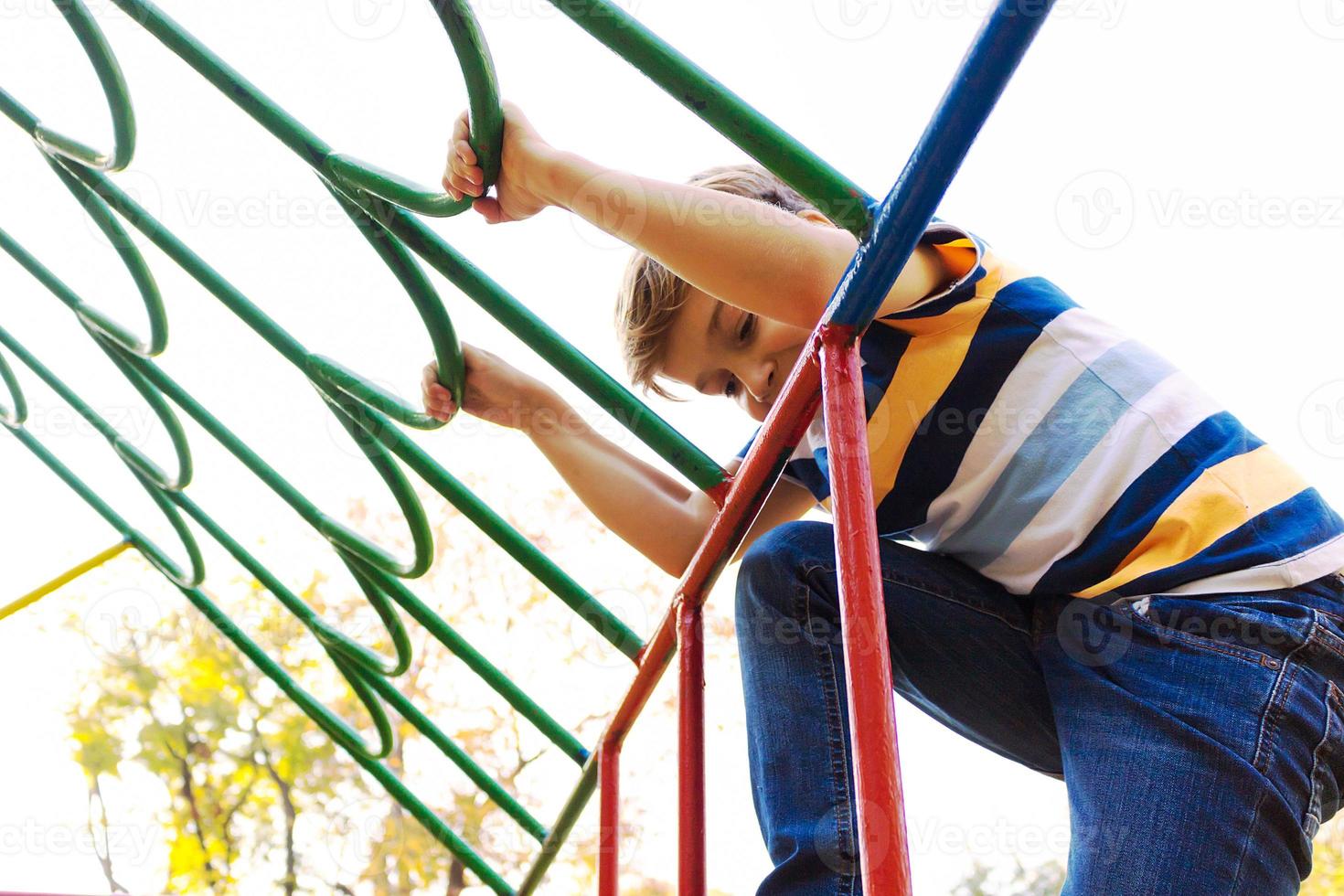 Happy kid having fun on the playground at the park. photo