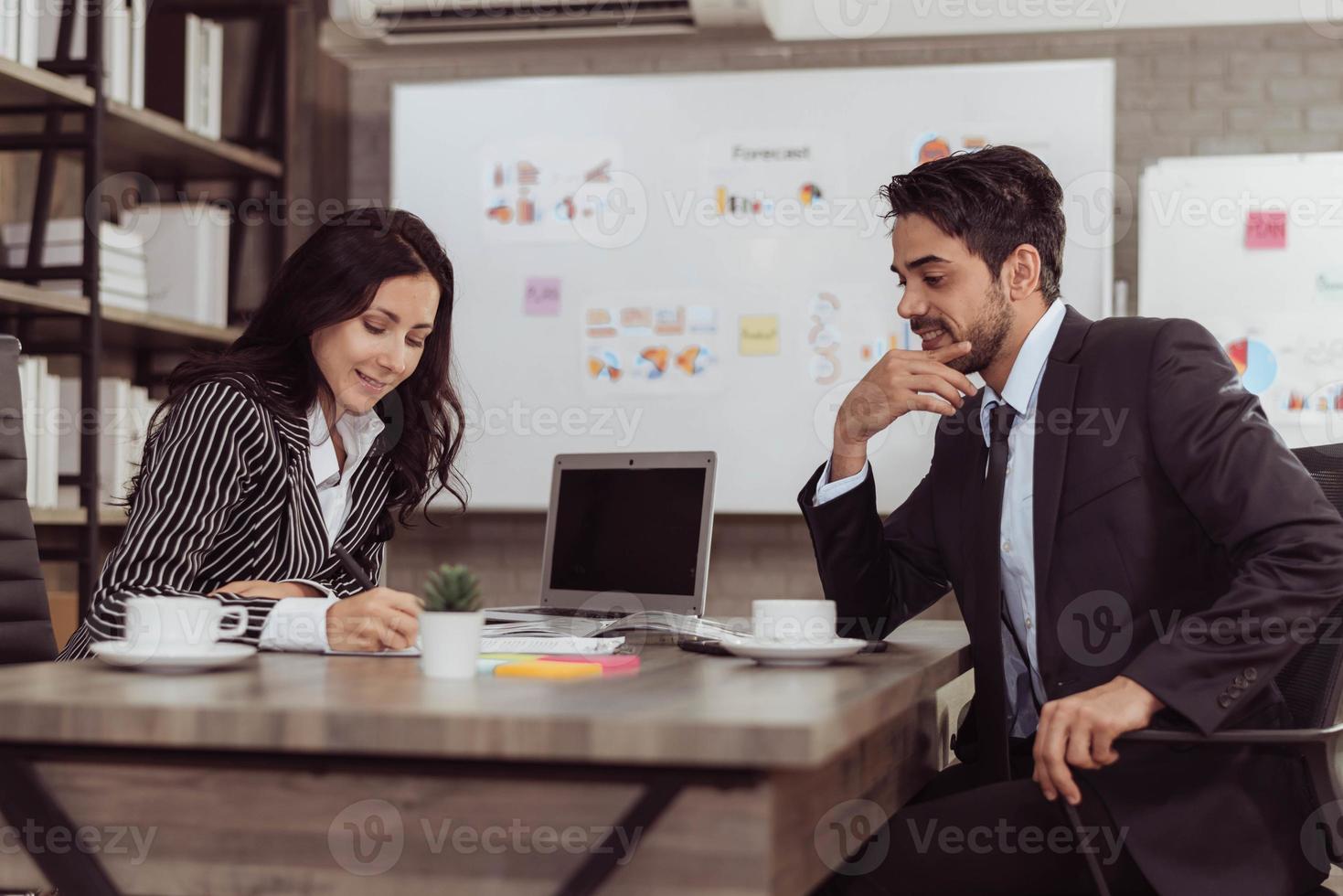 joven hombre y mujer de negocios trabajando juntos en el cargo. dos empresarios hablando de proyecto en la sala de oficina. foto