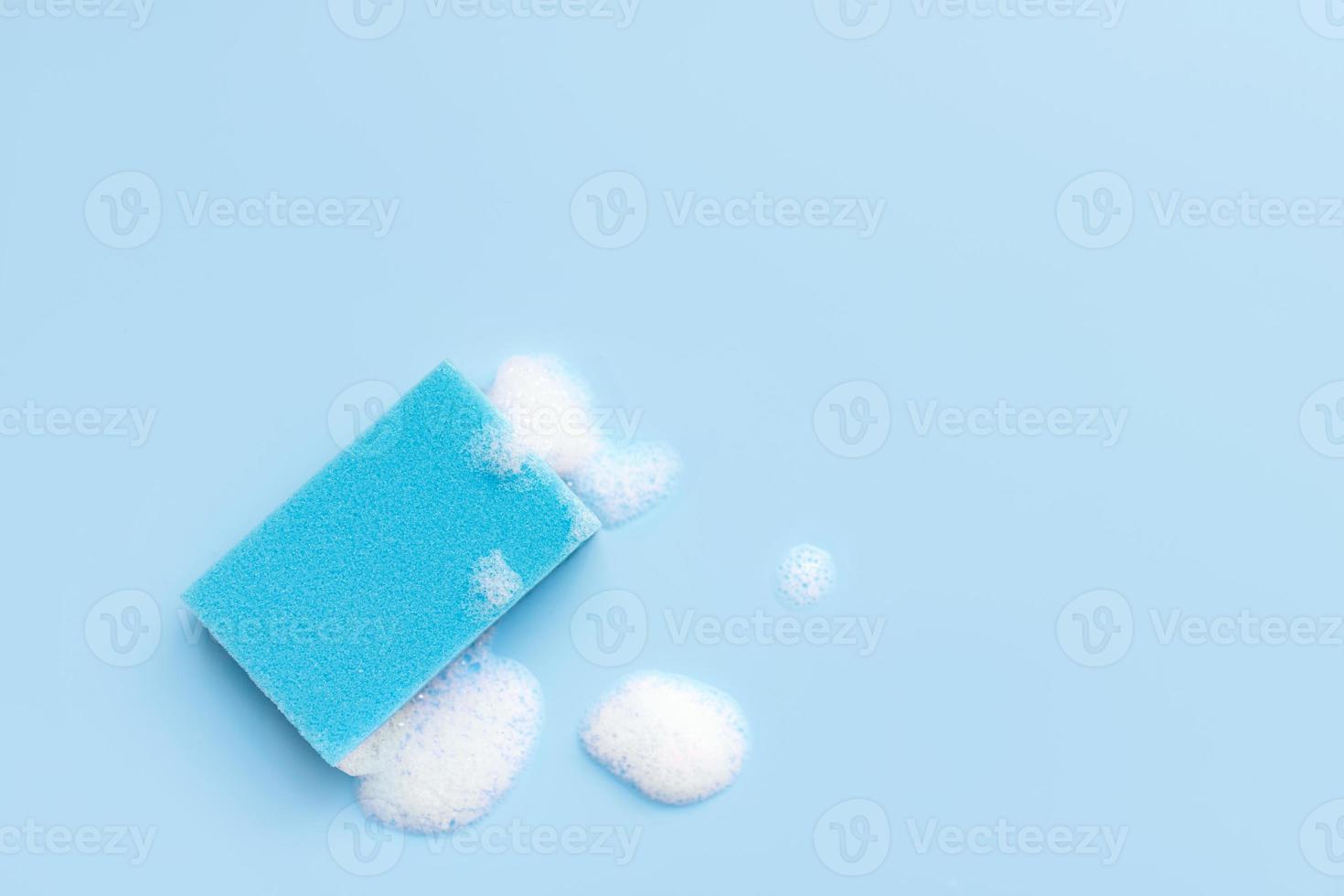 Multicolored sponges for cleaning on a blue background. Space for text. photo