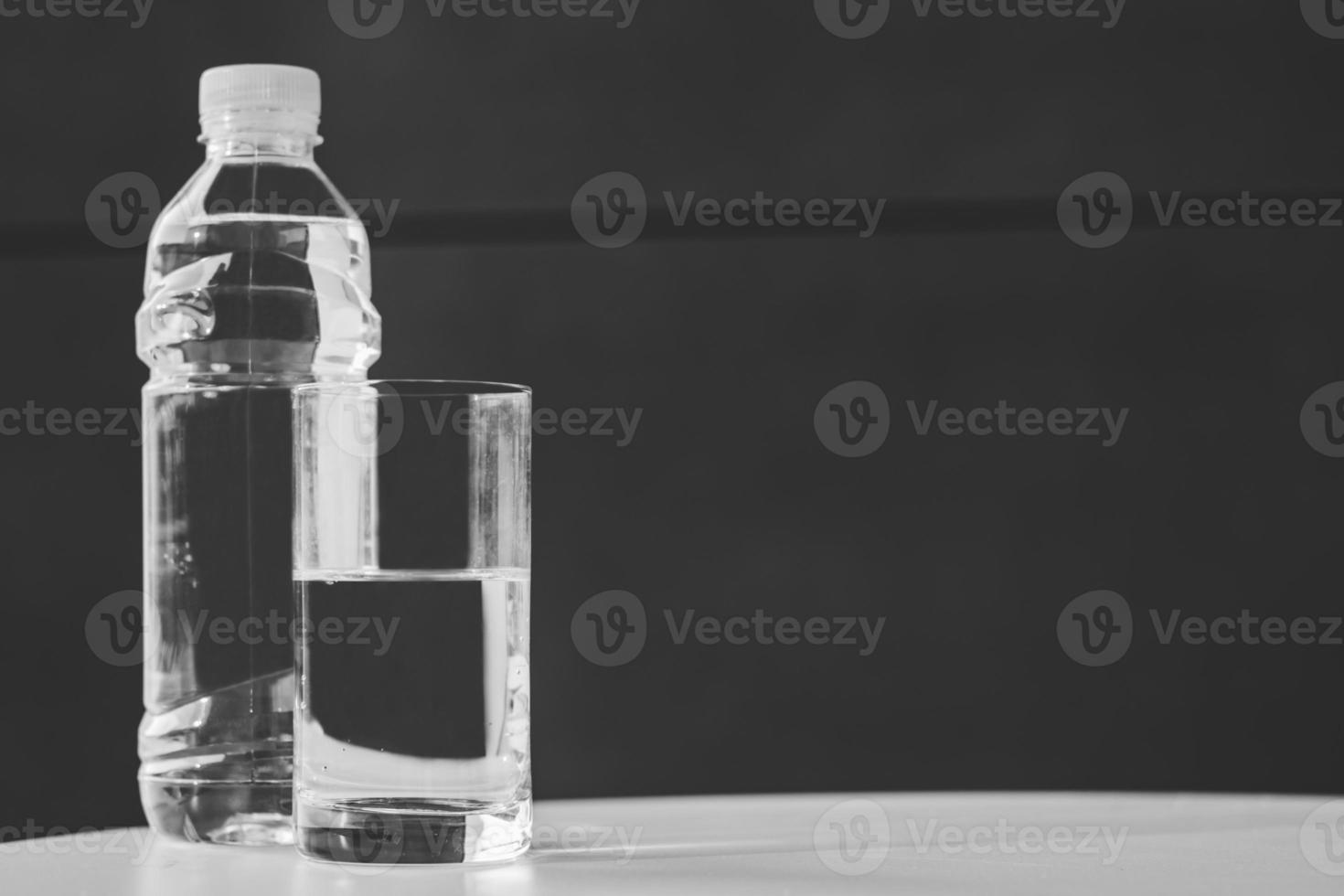 Water bottle and half-full glass of water. photo