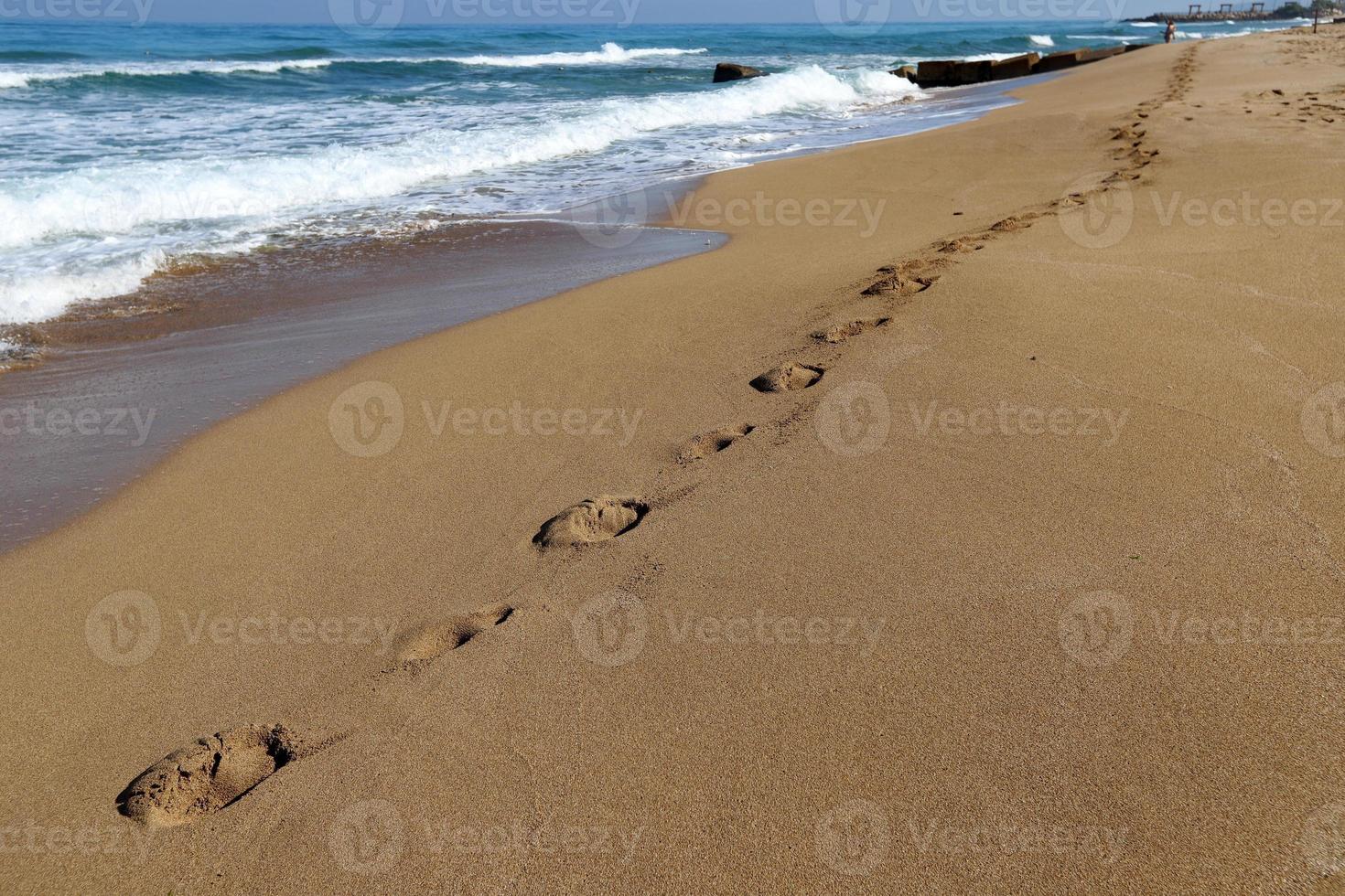 Footprints in the sand on the shores of the Mediterranean Sea. photo