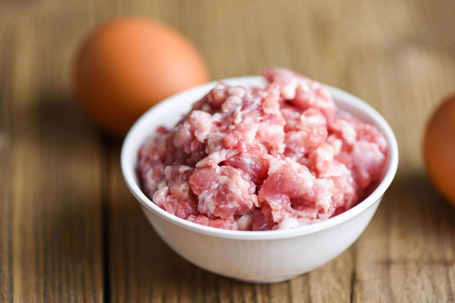 carne picada, carne picada o molida carne de cerdo cruda en un tazón con carne de cerdo molida de huevo foto