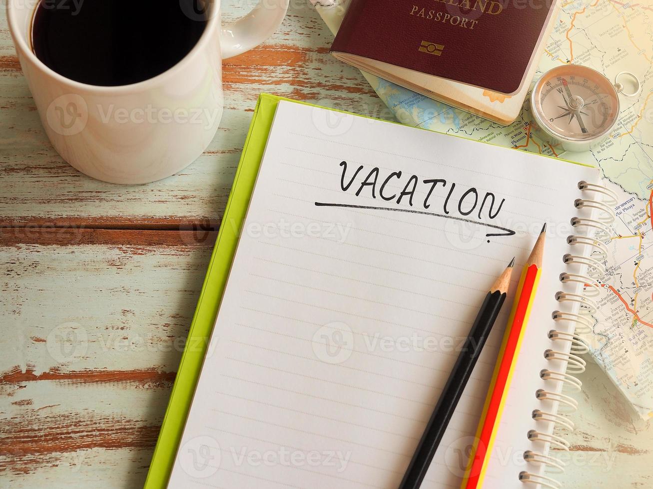 Blank space notebook on wooden table in vacation plans concept. photo