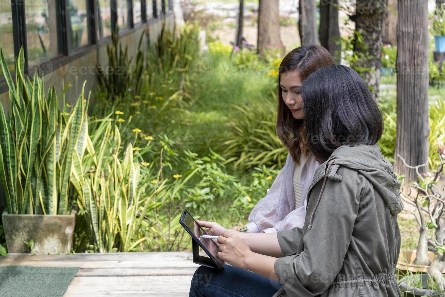Two women discussing business while using a tablet. Inside the coffee shop garden photo