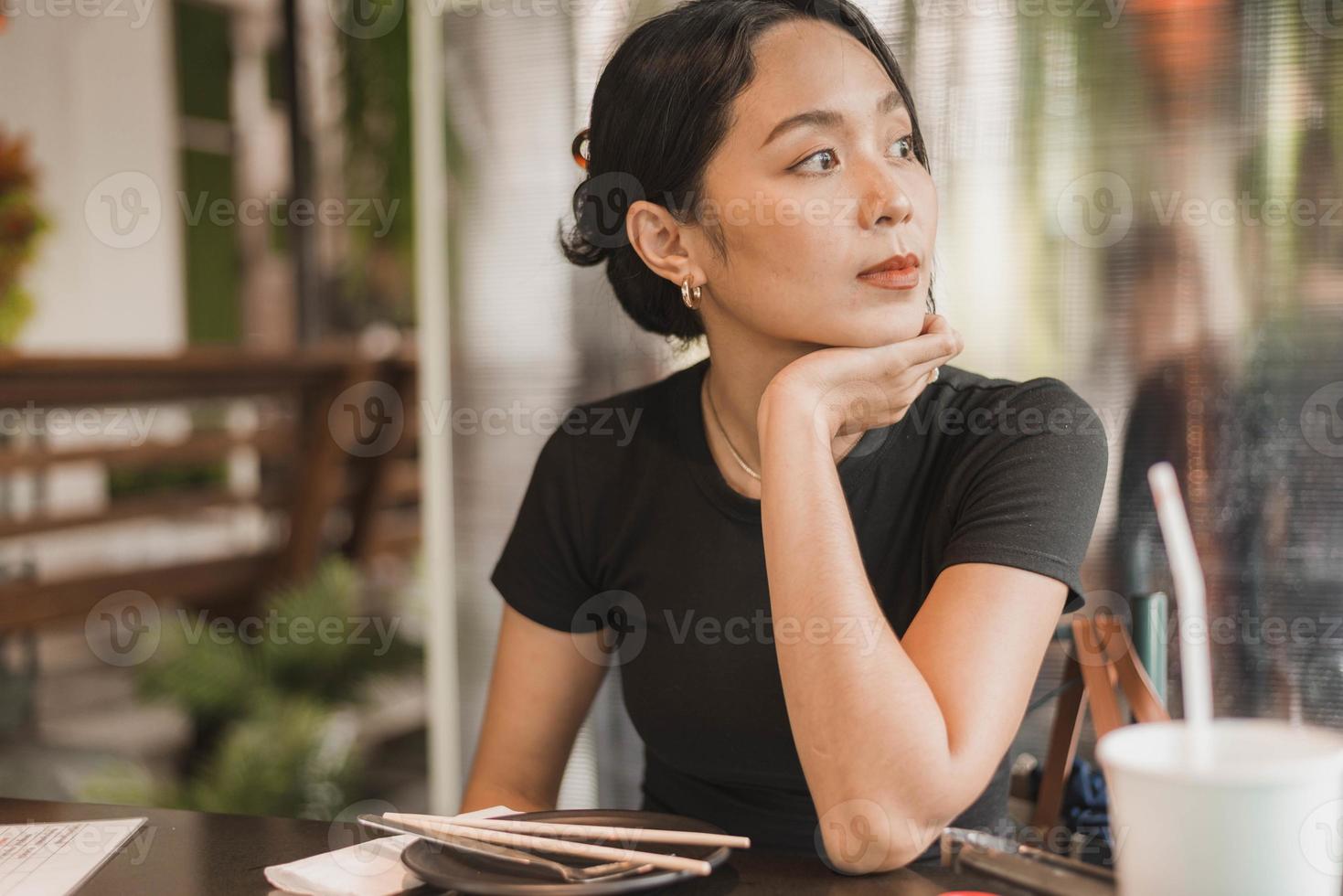 Adult woman in cafe and checking messenger while using smartphone. oung woman using phone, Asian woman using smartphone at cafe. photo