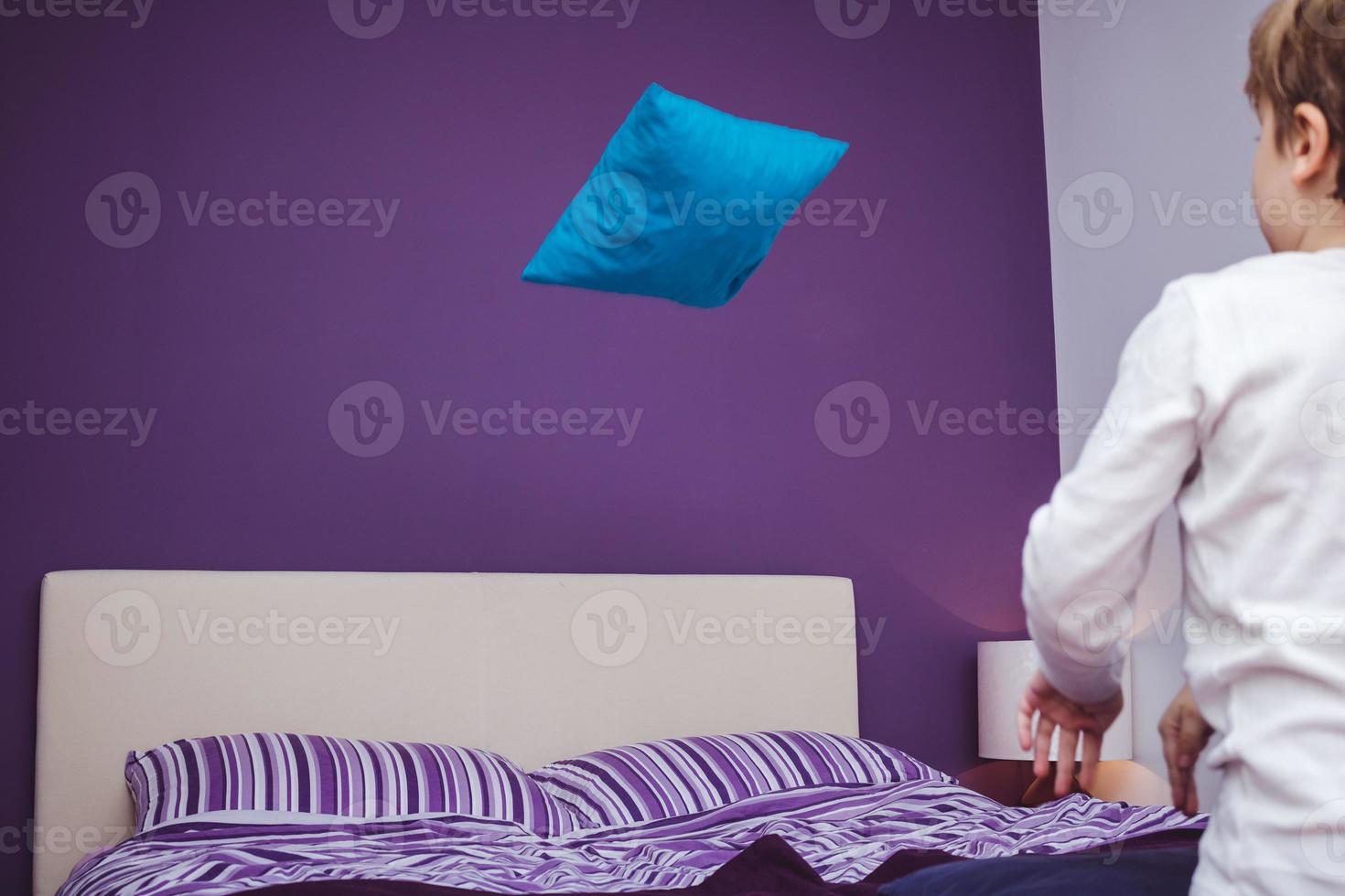 Small kid throwing pillow on the bed. 11225416 Stock Photo at Vecteezy