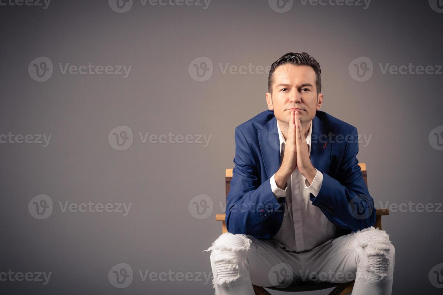Portrait of pensive businessman sitting against the wall. photo