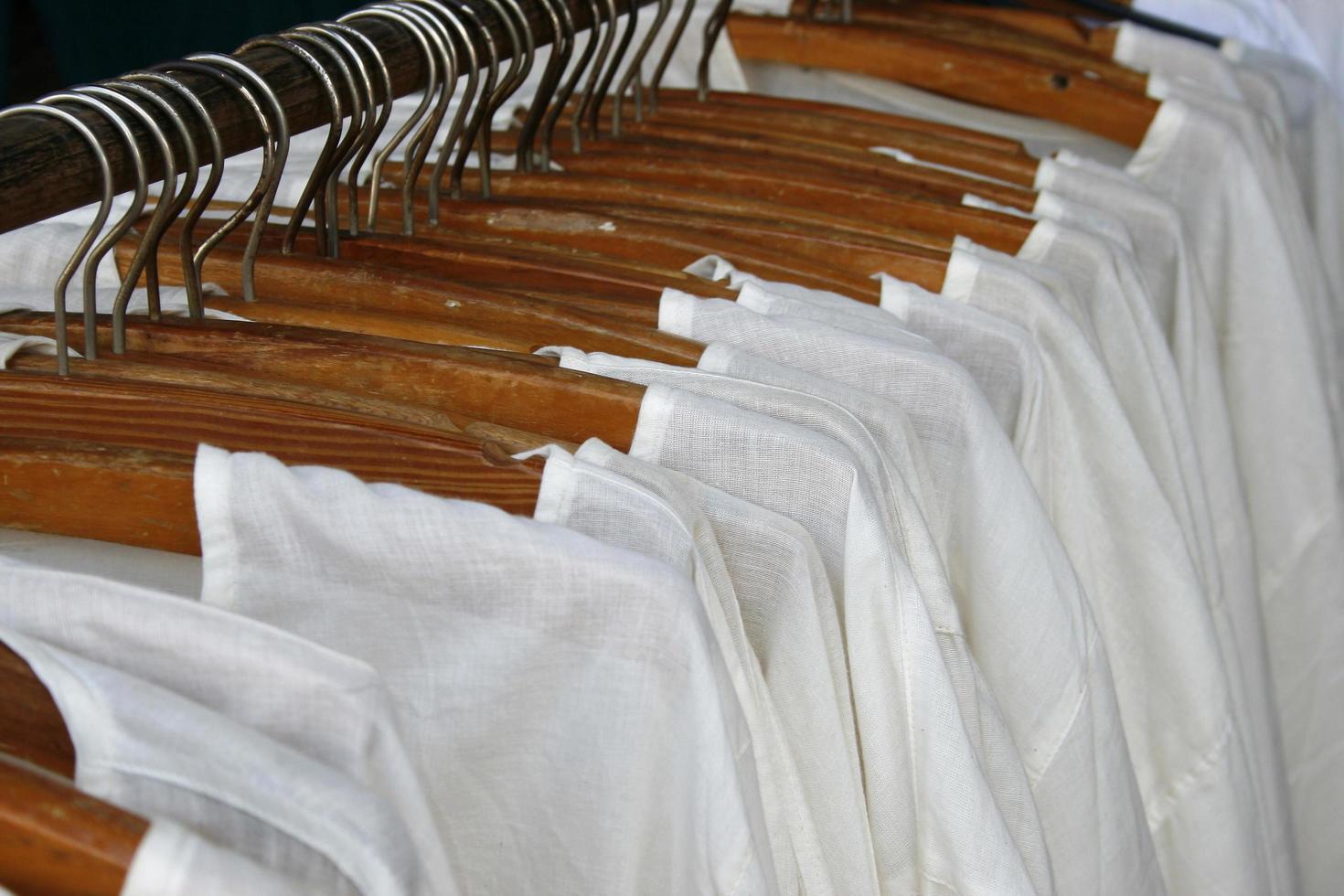 row of white shirts hanging on photo