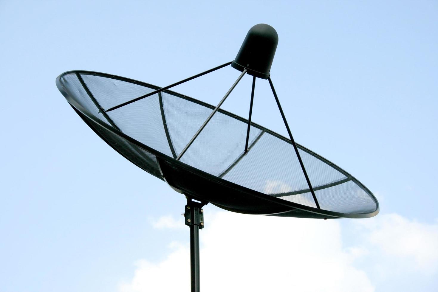 Satellite dish in blue sky photo