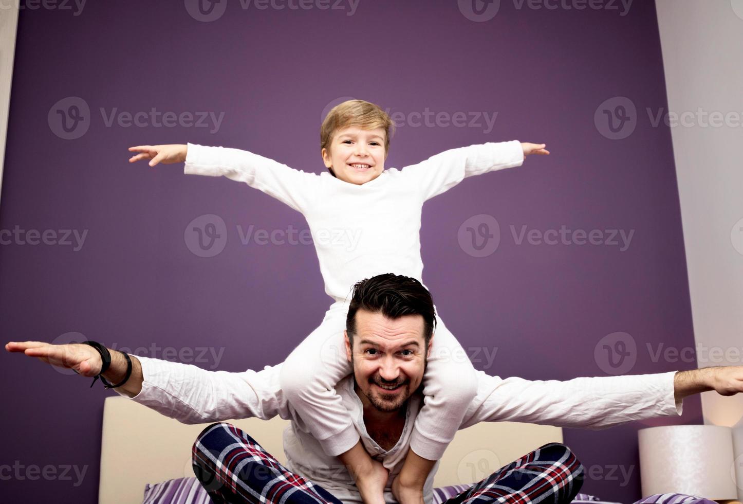 Below view of playful father and son in bedroom. photo
