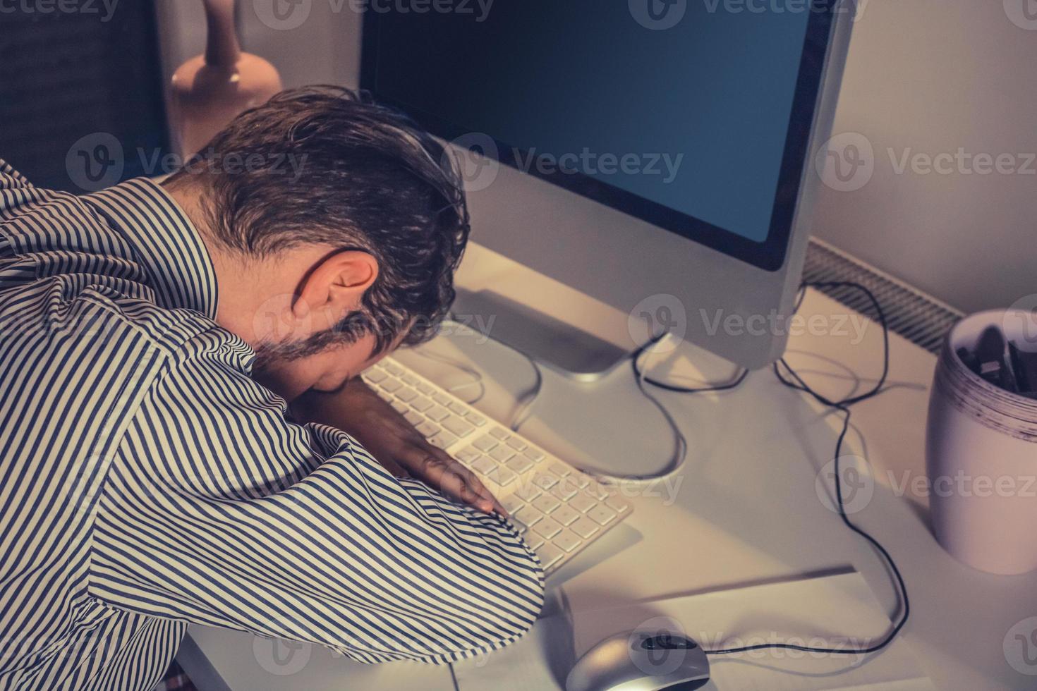 Businessman feeling exhausted while working late at night. photo