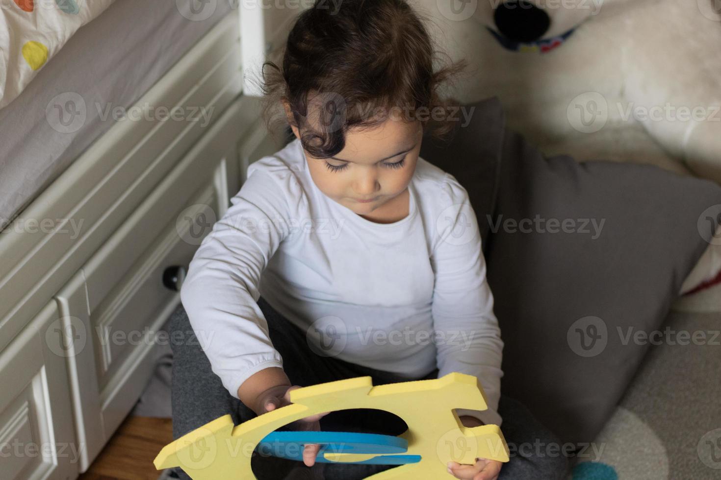 Little girl playing with puzzles. photo