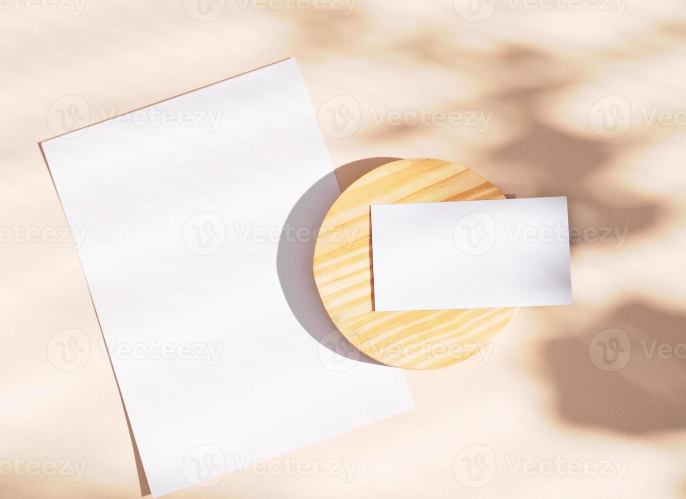 Flat lay of branding identity business name card and blank paper on yellow background, light and shadow shape leaves, minimal concept for design photo