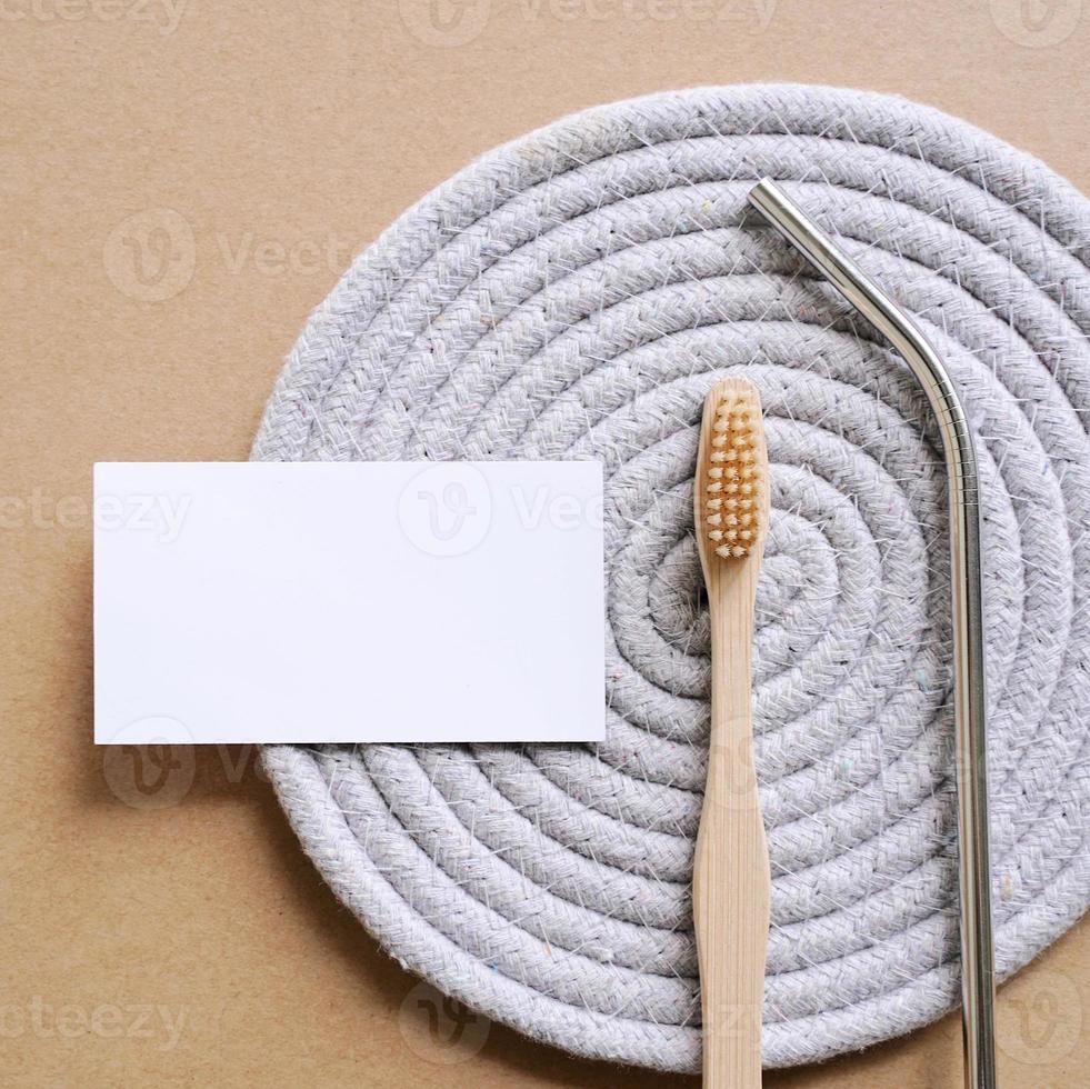 Flat lay branding identity business name card of sustainable products, stainless straw and bamboo toothbrush, minimal style photo